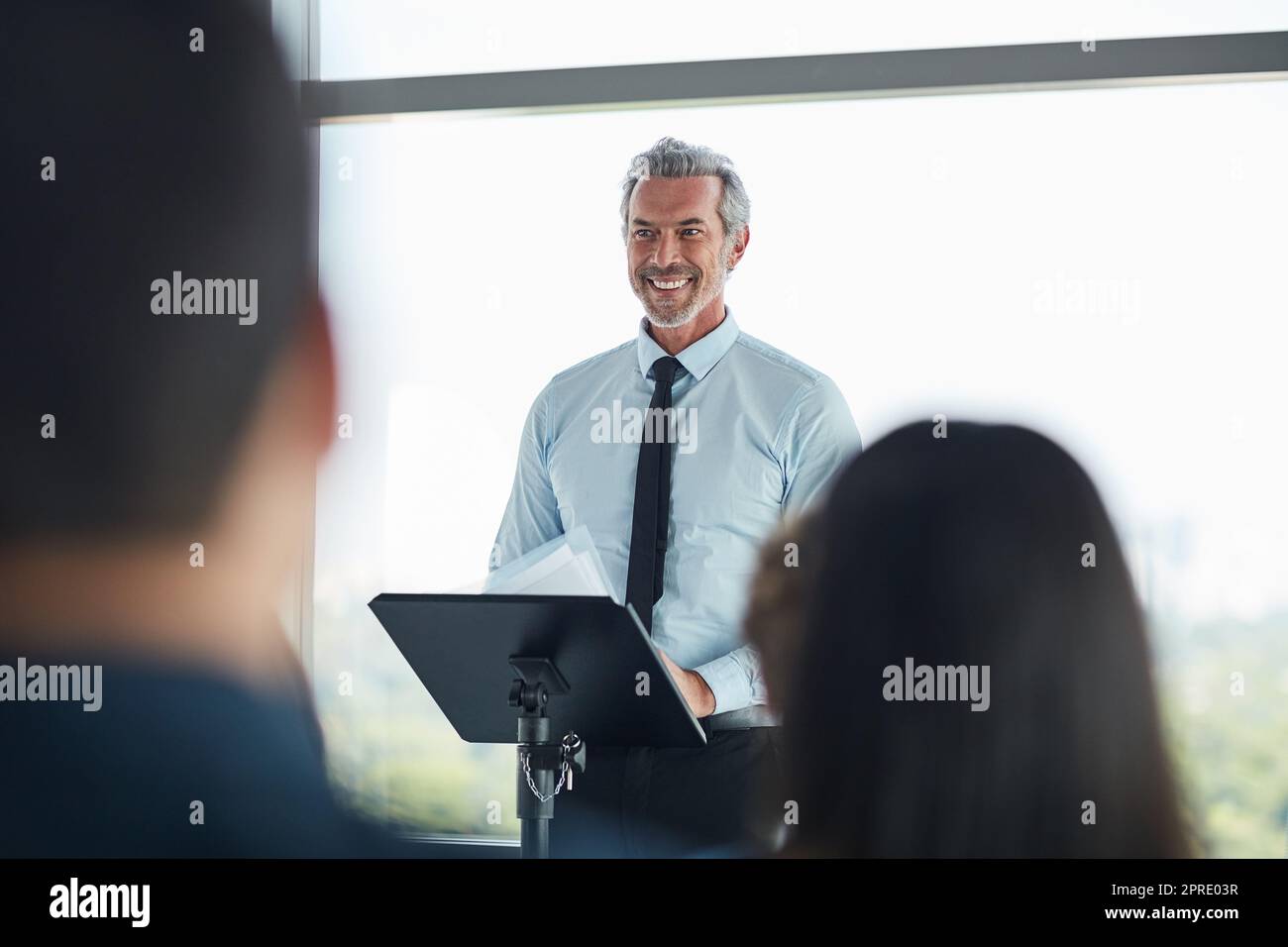 Gespräch mit Haltung und Zweck. Ein hübscher reifer Geschäftsmann, der auf einer Geschäftskonferenz spricht. Stockfoto
