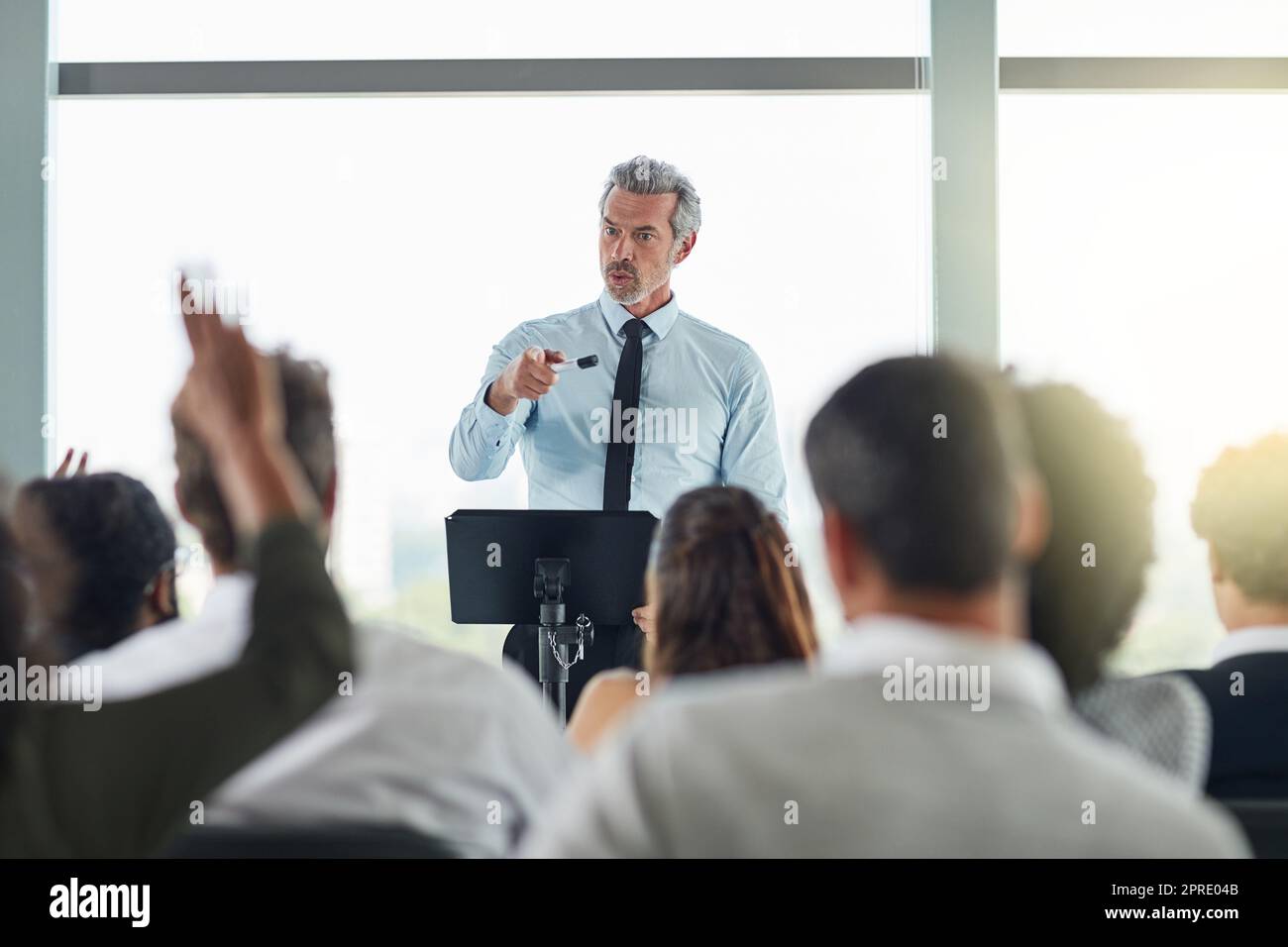Ja, Sie haben eine Frage. Ein hübscher reifer Geschäftsmann, der auf einer Geschäftskonferenz spricht. Stockfoto