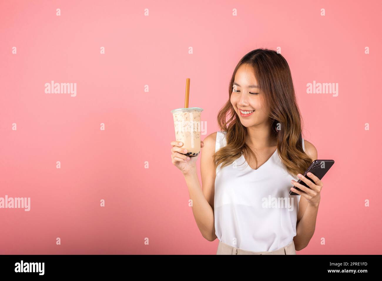Eine Frau, die braunen, zuckergeschmacklichen Tapioka-Perlen-Seifenmilchtee trinkt Stockfoto