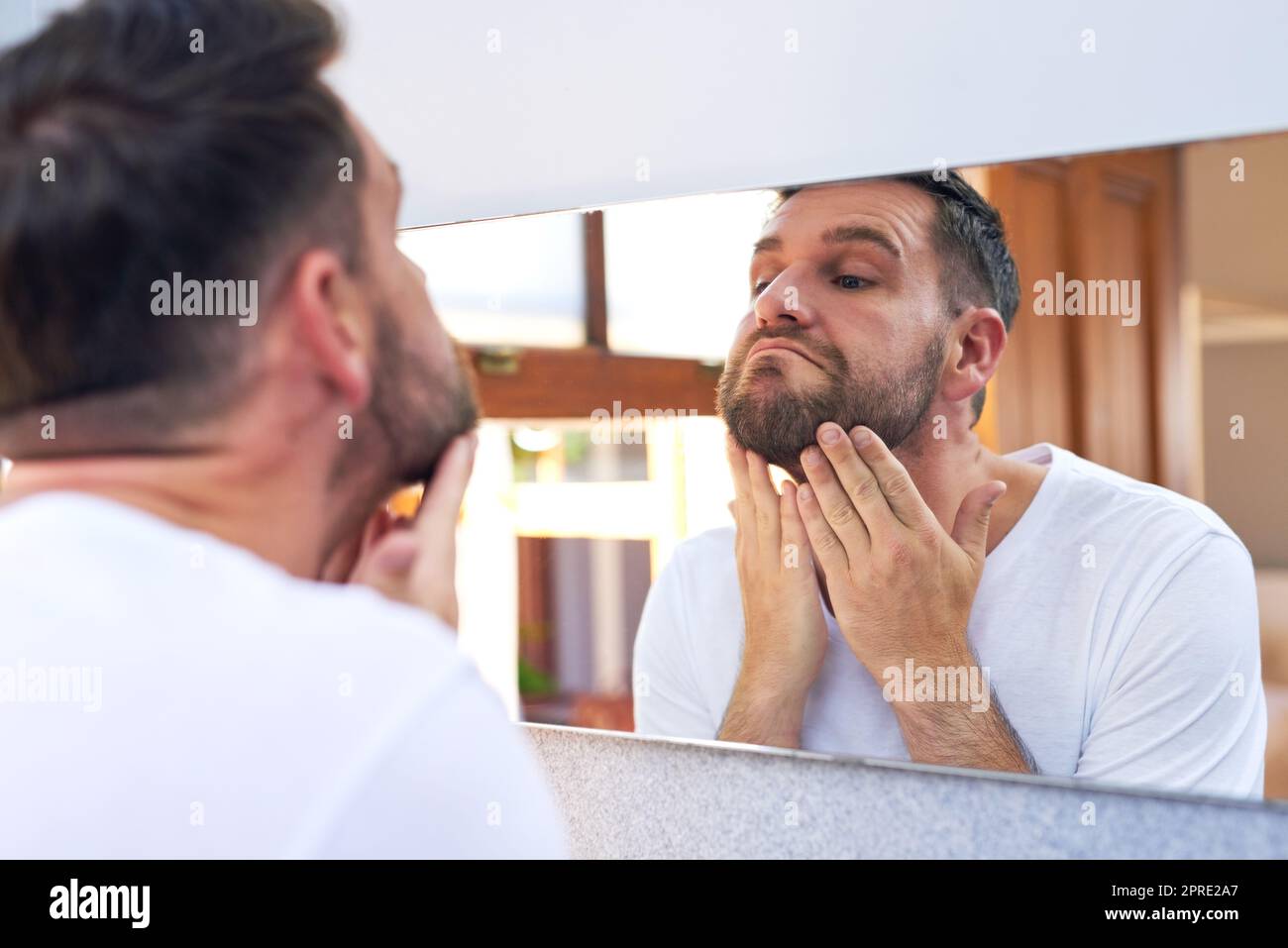 Es wird jetzt ein bisschen unscharf. Ein hübscher junger Mann, der zu Hause seine morgendliche Routine durchläuft. Stockfoto