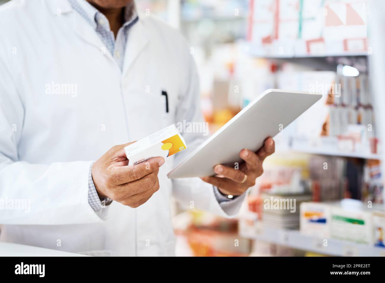 Wir recherchieren, um die besten Produkte zu finden. Nahaufnahme eines nicht erkennbaren Apothekers, der eine digitale Tablette in einem Chemiker verwendet. Stockfoto