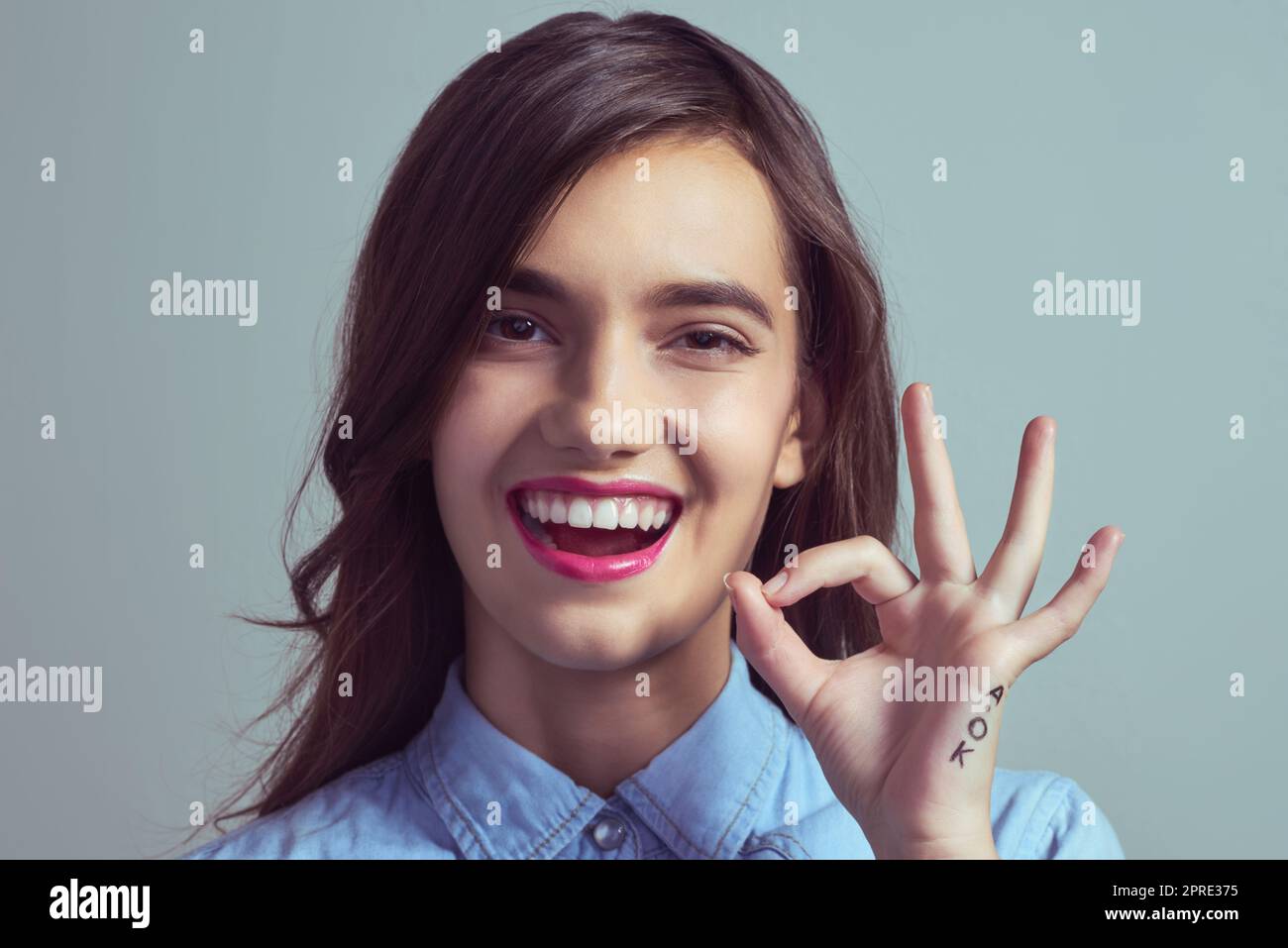 Perfektion. Studioportrait einer attraktiven jungen Frau, die mit der Hand vor grauem Hintergrund ein A-Okay-Zeichen macht. Stockfoto