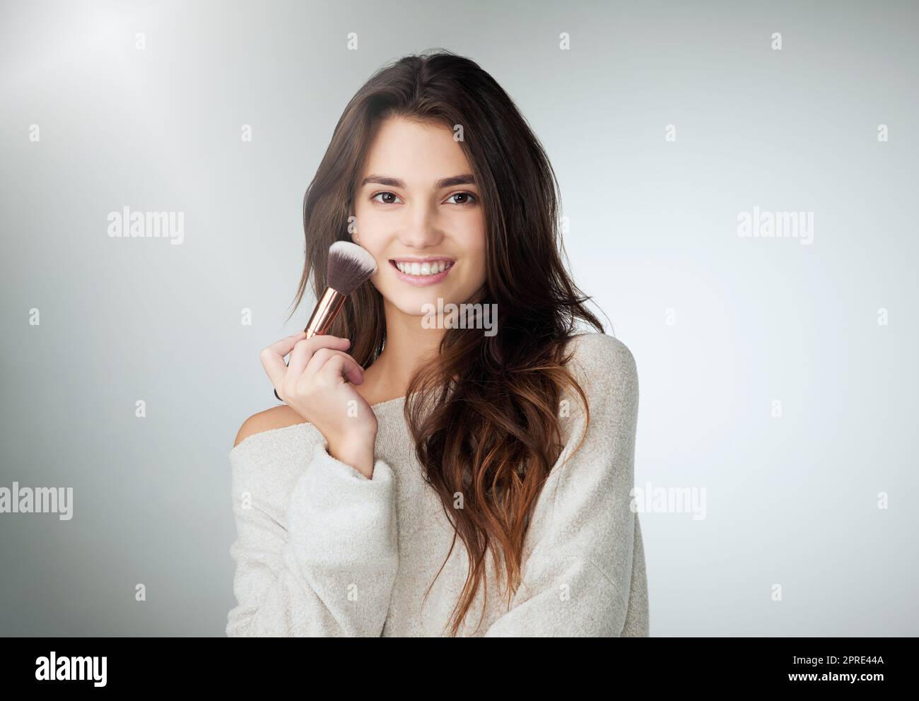 Was würde ich ohne ein wenig Erröten tun. Studioaufnahme einer schönen jungen Frau, die vor einem grauen Hintergrund posiert. Stockfoto