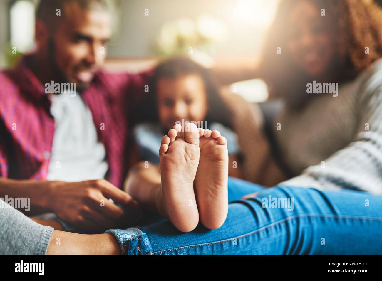 Die wichtigste Zeit ist die Zeit der Familie. Eine dreiköpfige Familie entspannt sich zu Hause auf dem Sofa. Stockfoto