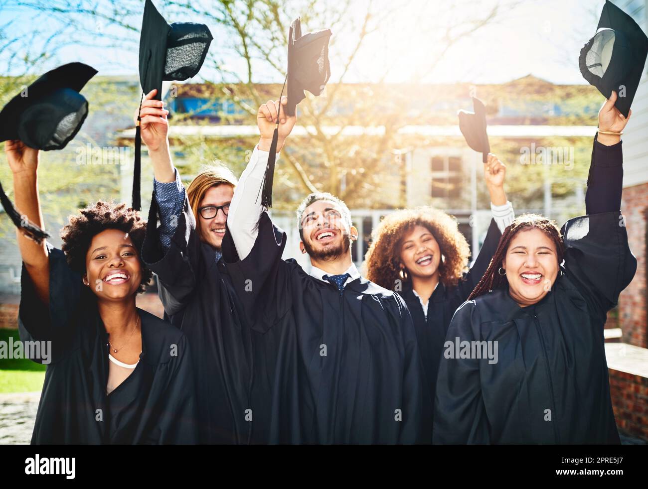 Waren bereit, die Zukunft zu übernehmen. Eine Gruppe von Studenten warf ihre Mützen in die Luft nach dem Studium. Stockfoto