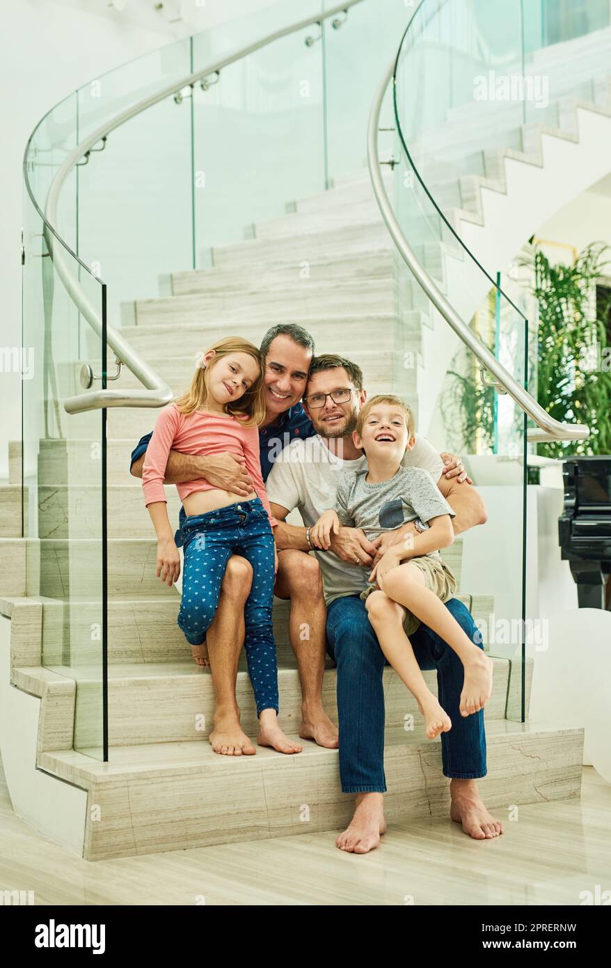 Teilen Sie die Liebe. Ganzkörperportrait einer liebevollen vierköpfigen Familie auf der Treppe zu Hause. Stockfoto