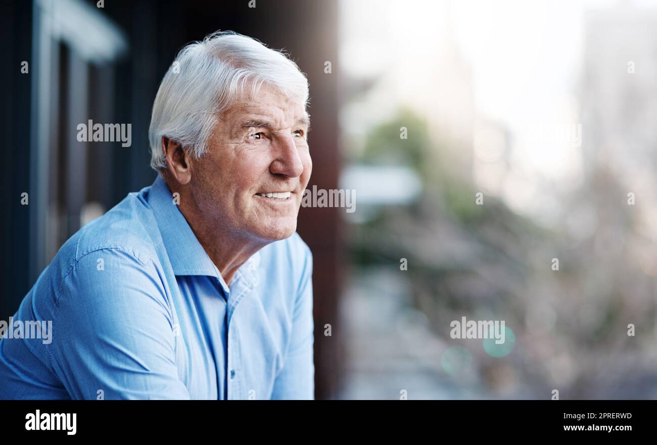 Es ist gut, ein wenig aus dem Büro zu kommen. Ein älterer Geschäftsmann außerhalb des Büros mit Blick auf die Stadt. Stockfoto