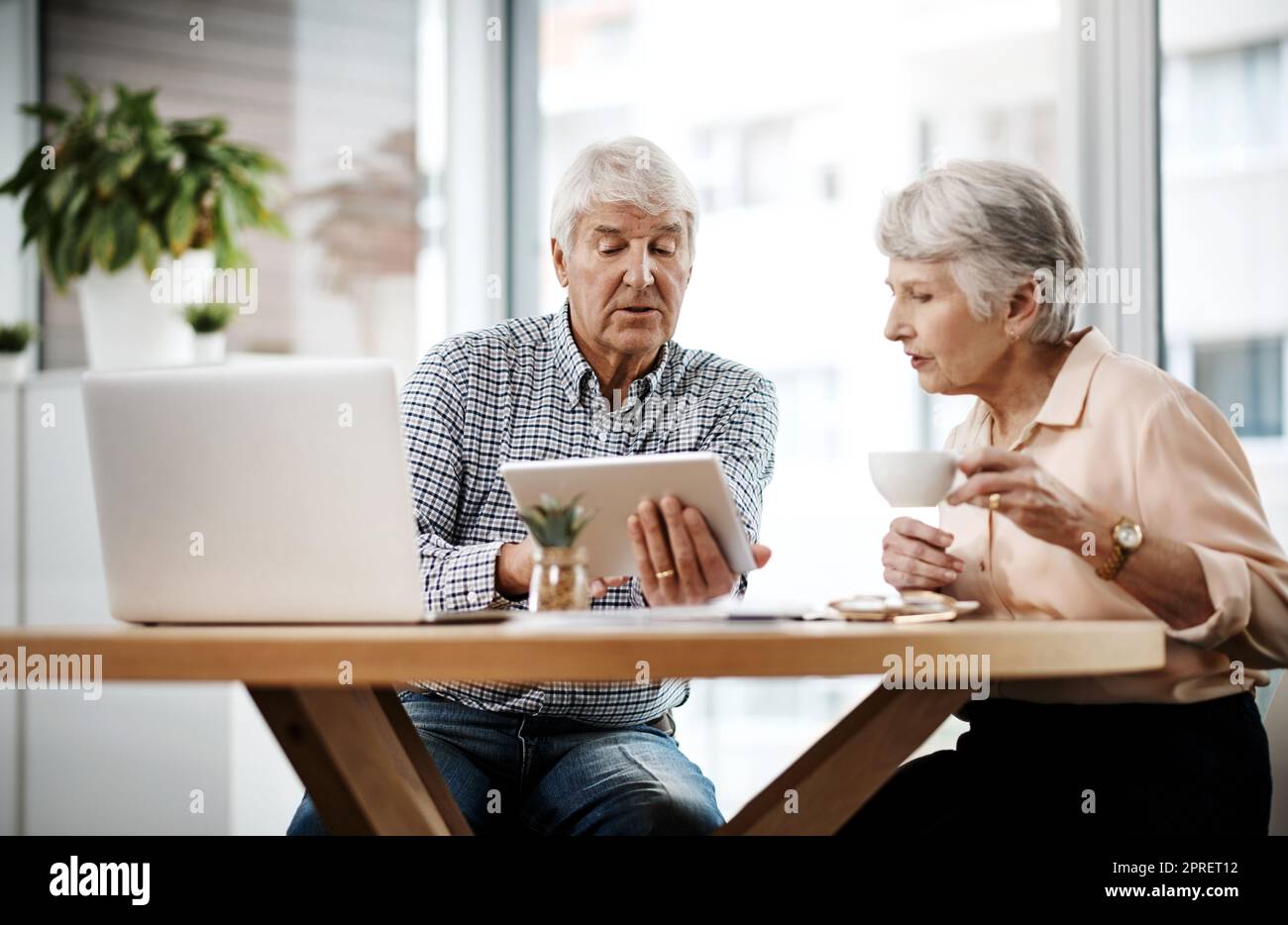 Hier erfahren Sie, wie unsere Finanzen aussehen. Aufnahme eines älteren Paares, das zu Hause an seinen Finanzen arbeitet. Stockfoto
