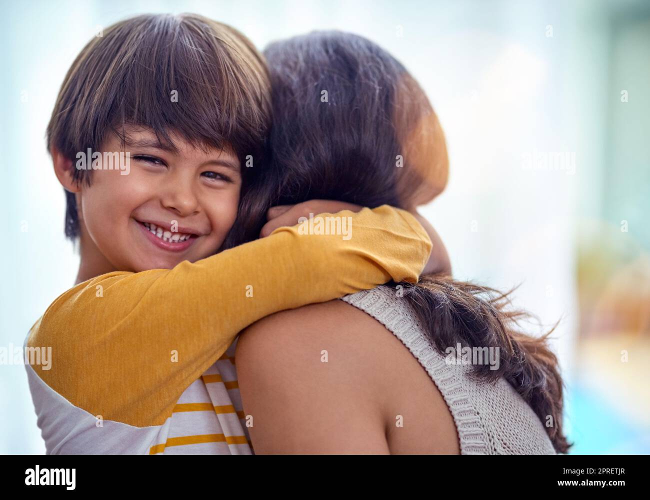 Die Mutter Sohn Verbindung, was für eine schöne Bindung. Ein entzückender kleiner Junge liebevoll umarmt seine Mutter zu Hause. Stockfoto