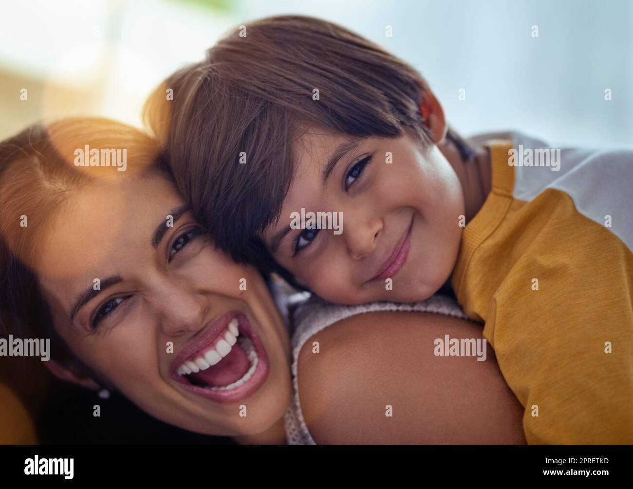 Nichts ganz so liebenswertes wie die Liebe einer Mutter. Ein entzückender kleiner Junge umarmte seine Mutter zu Hause liebevoll. Stockfoto