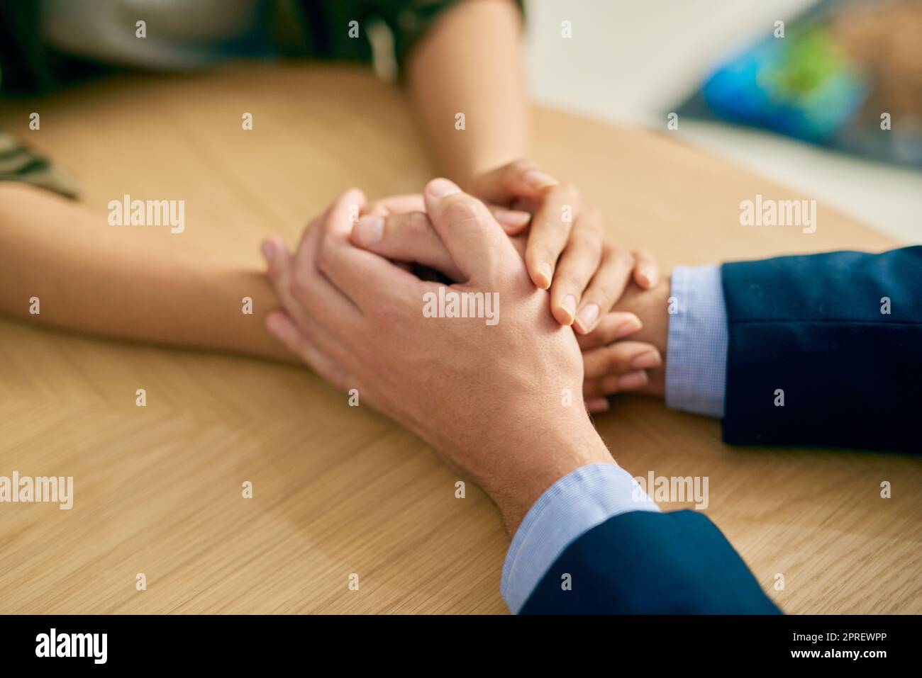 Mitgefühl, das Herz der Menschheit. Ein Geschäftsmann und eine Geschäftsfrau halten barmherzig die Hände an einem Tisch. Stockfoto