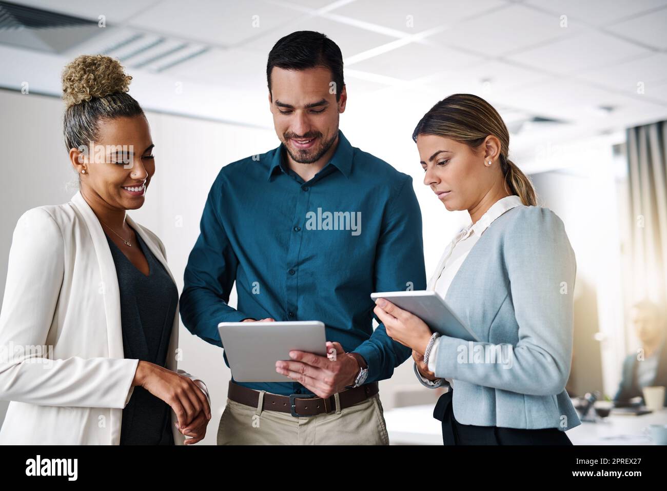 Eine Gruppe von Geschäftsleuten, die in einem Büro an einem digitalen Tablet arbeiten. Stockfoto