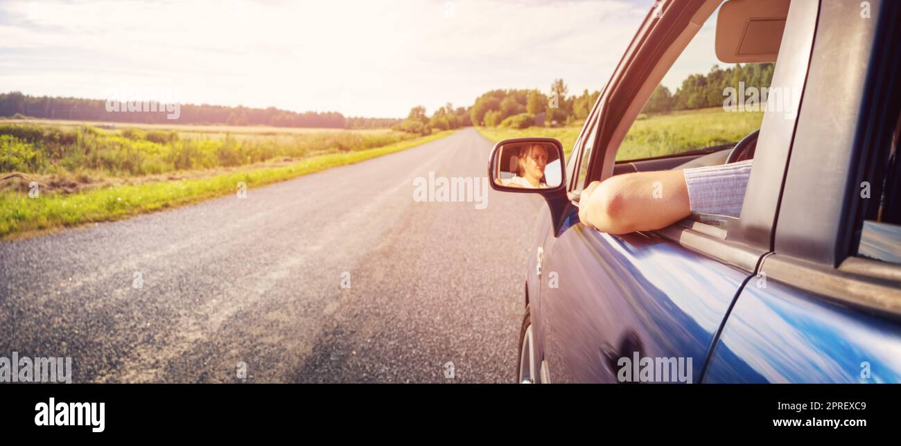 Junge Frau, die ihr Auto im Naturpark fährt Stockfoto