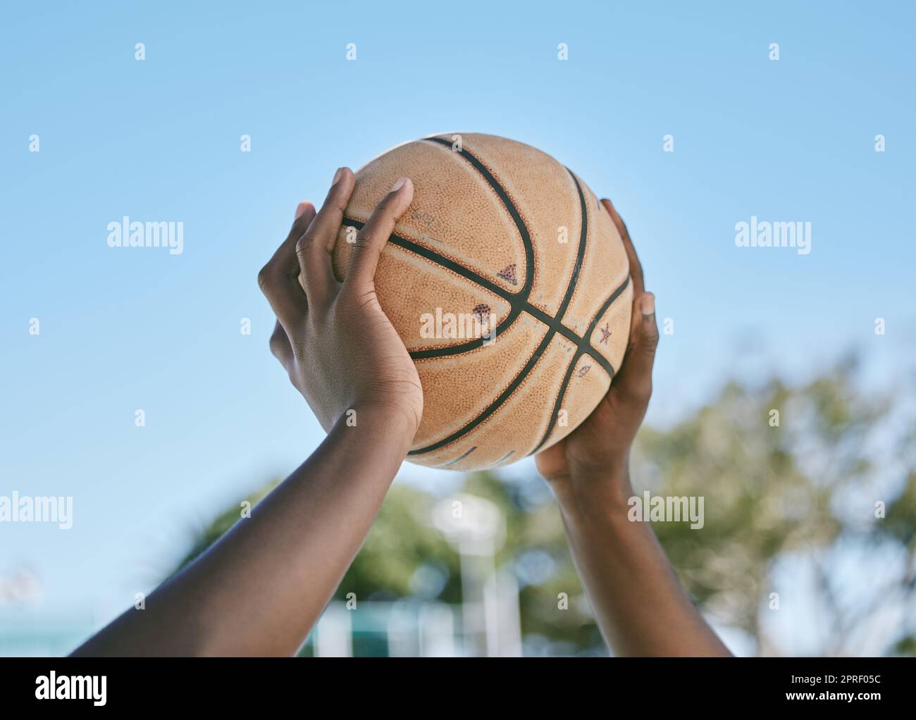 Basketball, Sport und Spielen mit einem Ball in den Händen eines Spielers, Athleten oder Profisportlers. Nahaufnahme eines Spiels oder Spiels draußen auf einem Platz für Gesundheit, Erholung und Spaß in der Sonne Stockfoto