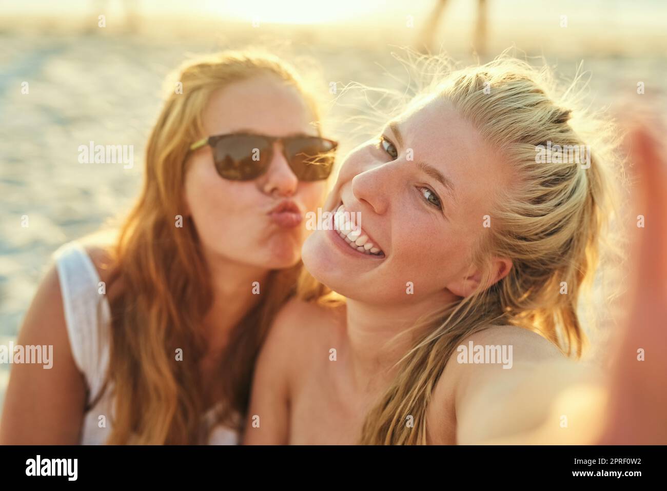 Sonnenbaden und Spaß. Junge weibliche beste Freundinnen am Strand. Stockfoto