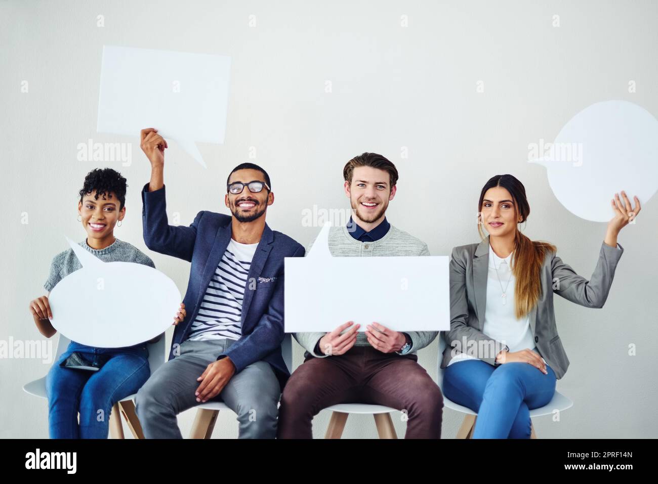 Eine vielfältige Gruppe kreativer Mitarbeiter hält Sprechblasen in sich. Stockfoto