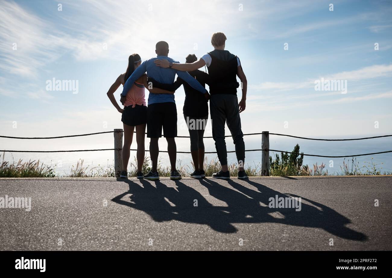 Am Ende lohnt sich alles. Eine Aufnahme einer Fitnessgruppe, die die Aussicht im Freien bewundert. Stockfoto