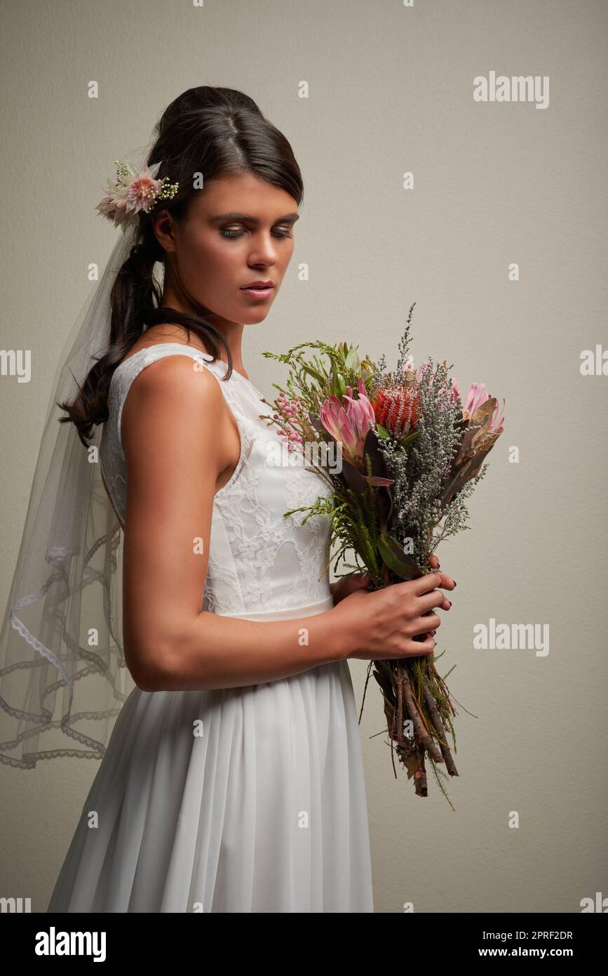 Bereit für den großen Tag. Studioaufnahme einer jungen, schönen Braut, die vor grauem Hintergrund posiert. Stockfoto