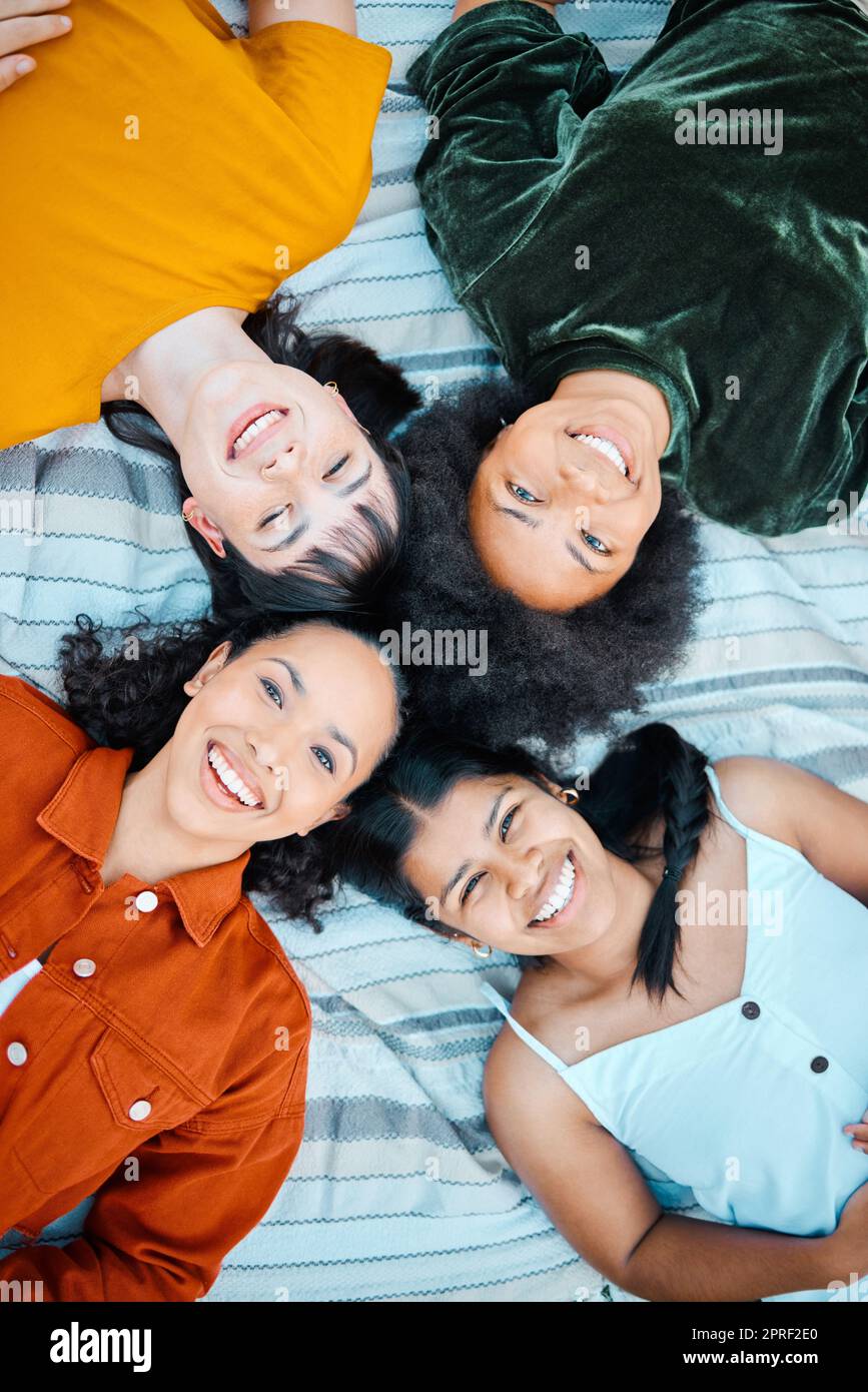 Freundschaft ist der Zement, der die Welt zusammenhält. Weibliche Freunde, die zusammen auf der Decke in einem Park liegen Stockfoto