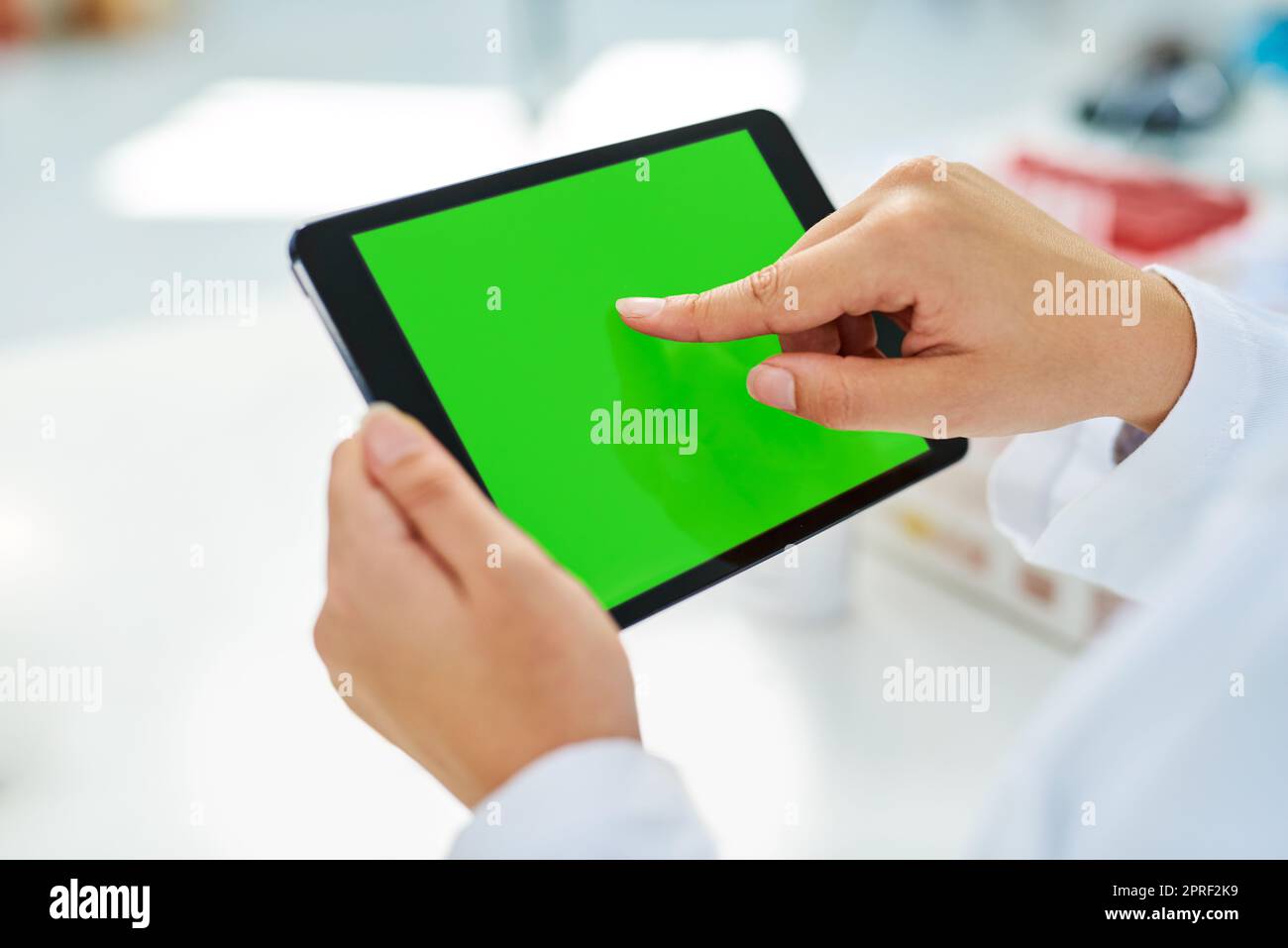 Entdeckungen mit der Welt teilen. Nahaufnahme eines nicht erkennbaren Wissenschaftlers, der in einem Labor ein digitales Tablet mit einem Chroma-Key-Bildschirm verwendet. Stockfoto
