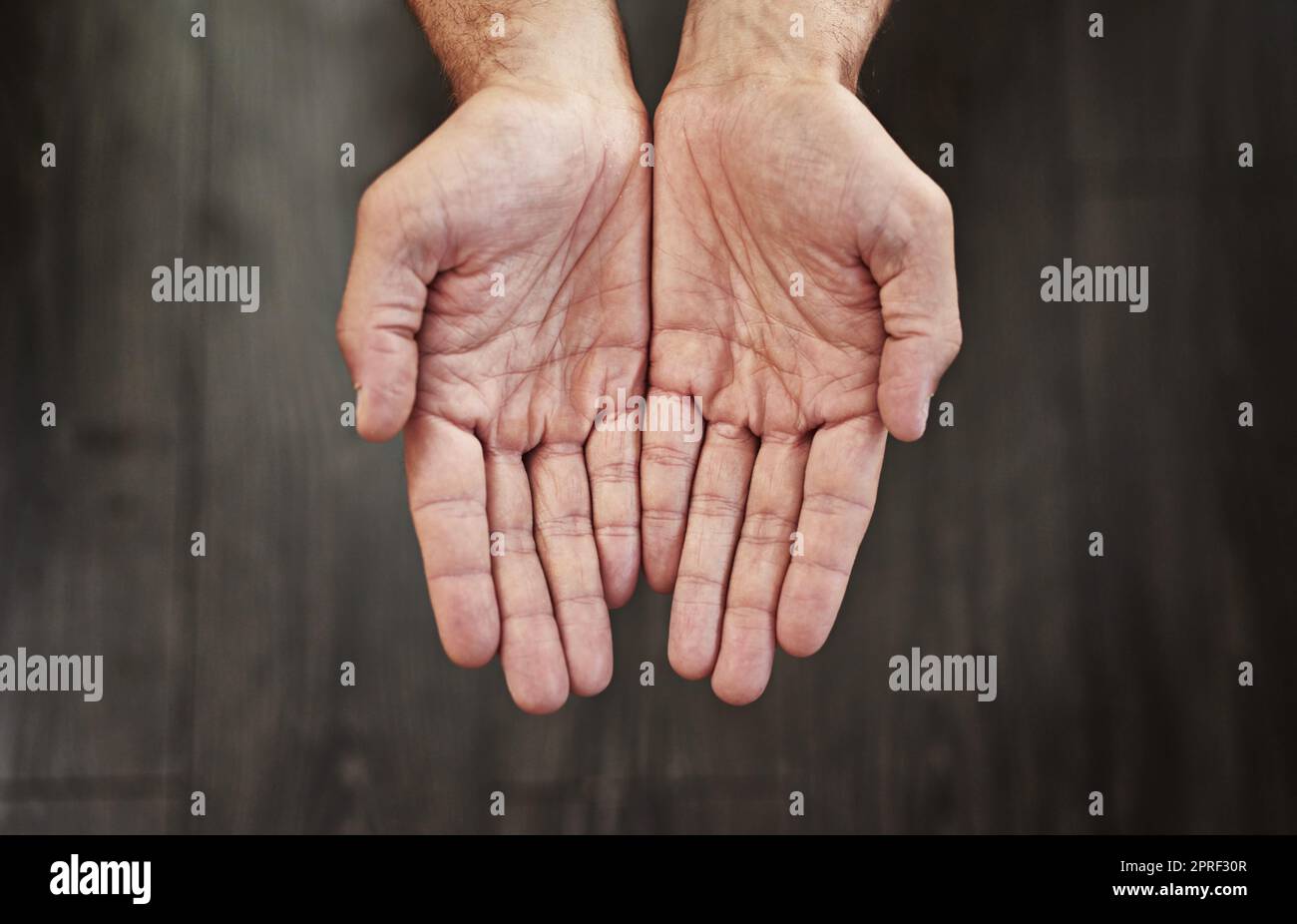 Alles, was Sie brauchen, ist eine Leihhand. Studioaufnahme einer nicht erkennbaren Person mit offenen Händen vor dunklem Hintergrund. Stockfoto