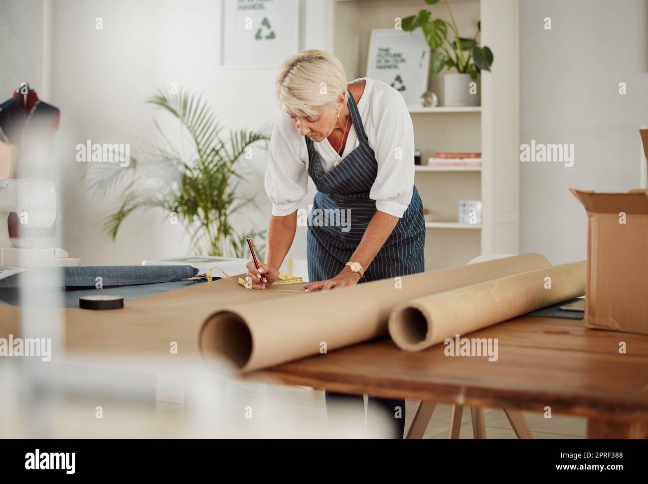 . Kleiderhersteller entwirft und skizziert während der Arbeit in einer kleinen Bekleidungsfabrik und einem kleinen Unternehmen. Designer und Geschäftsmann kreieren kreative Muster für die Stylingindustrie und das Modelager. Stockfoto