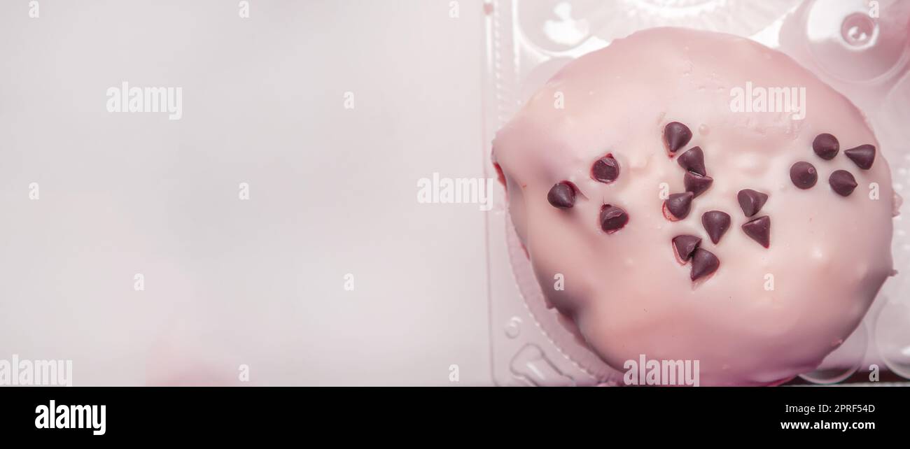 Köstlicher Donut mit Puderzucker und Schokoladenstückchen Draufsicht, Banner mit einer Kopie des Raumes links, rosa Färbung Stockfoto
