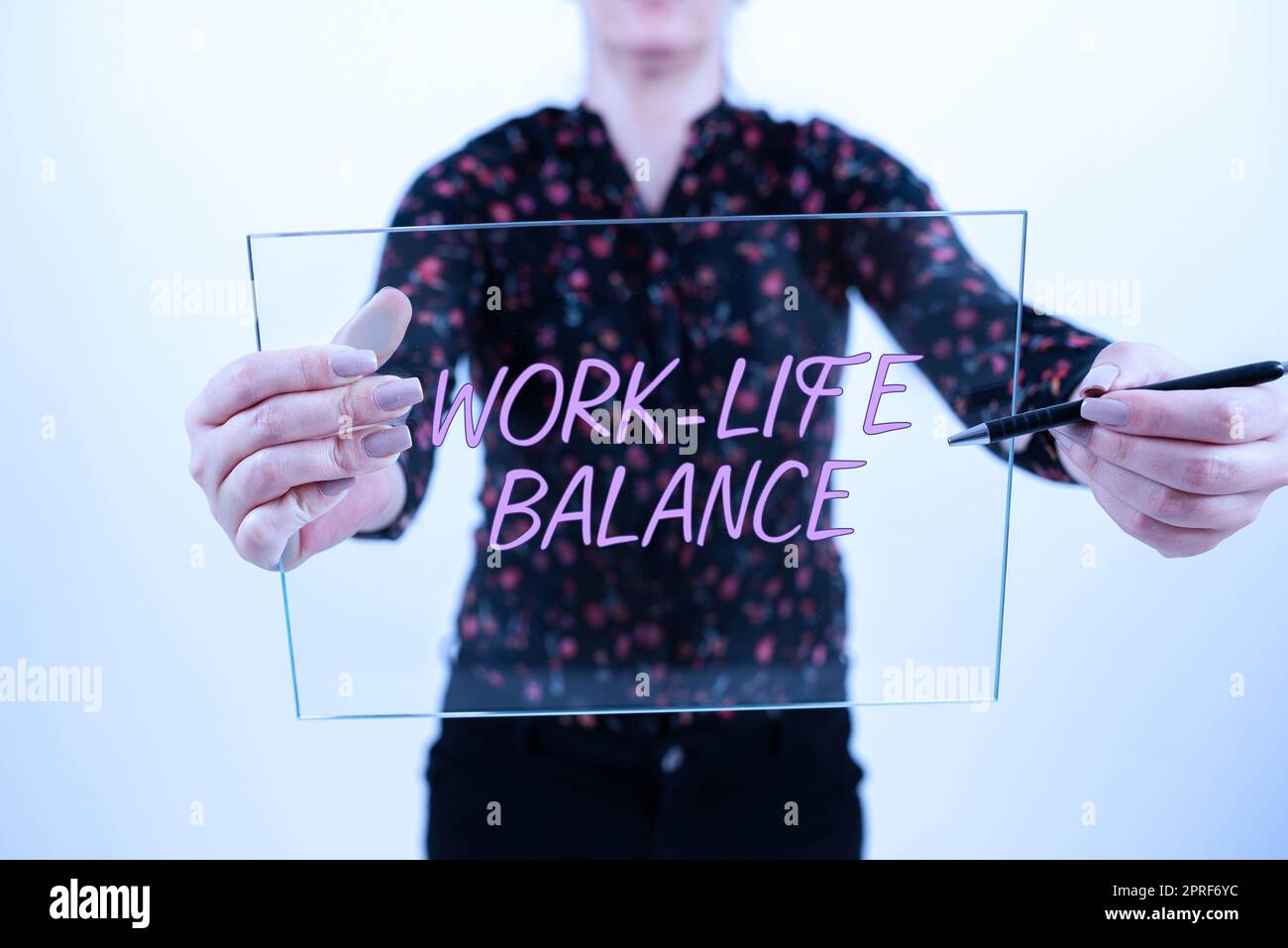 Handschriftlicher Text Work Life Balance. Konzept Bedeutung der zeitlichen Aufteilung zwischen Arbeit oder Familie und Freizeit Lady steht im Vordergrund und hält eine Präsentation, um Projektziele zu erreichen. Stockfoto