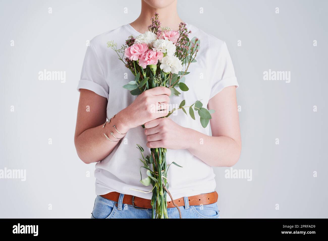 Ich möchte mich wie die Blumen frei fühlen. Studioaufnahme einer nicht erkennbaren Frau, die einen Blumenstrauß vor einem grauen Hintergrund hält. Stockfoto