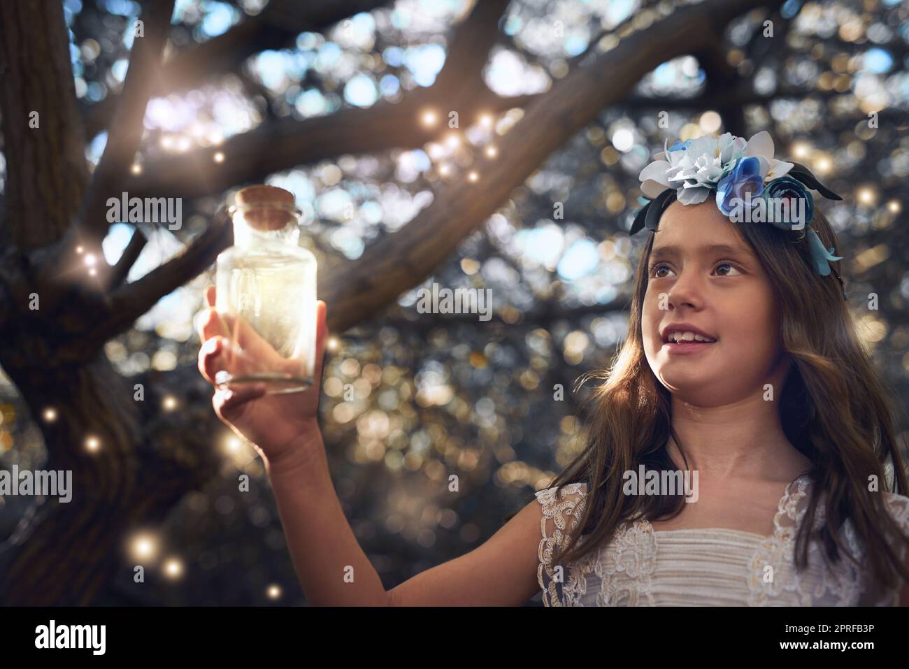 Sie glühen wie Feen. Ein kleines Mädchen, das draußen in einem Glas Glühwürmchen fängt. Stockfoto