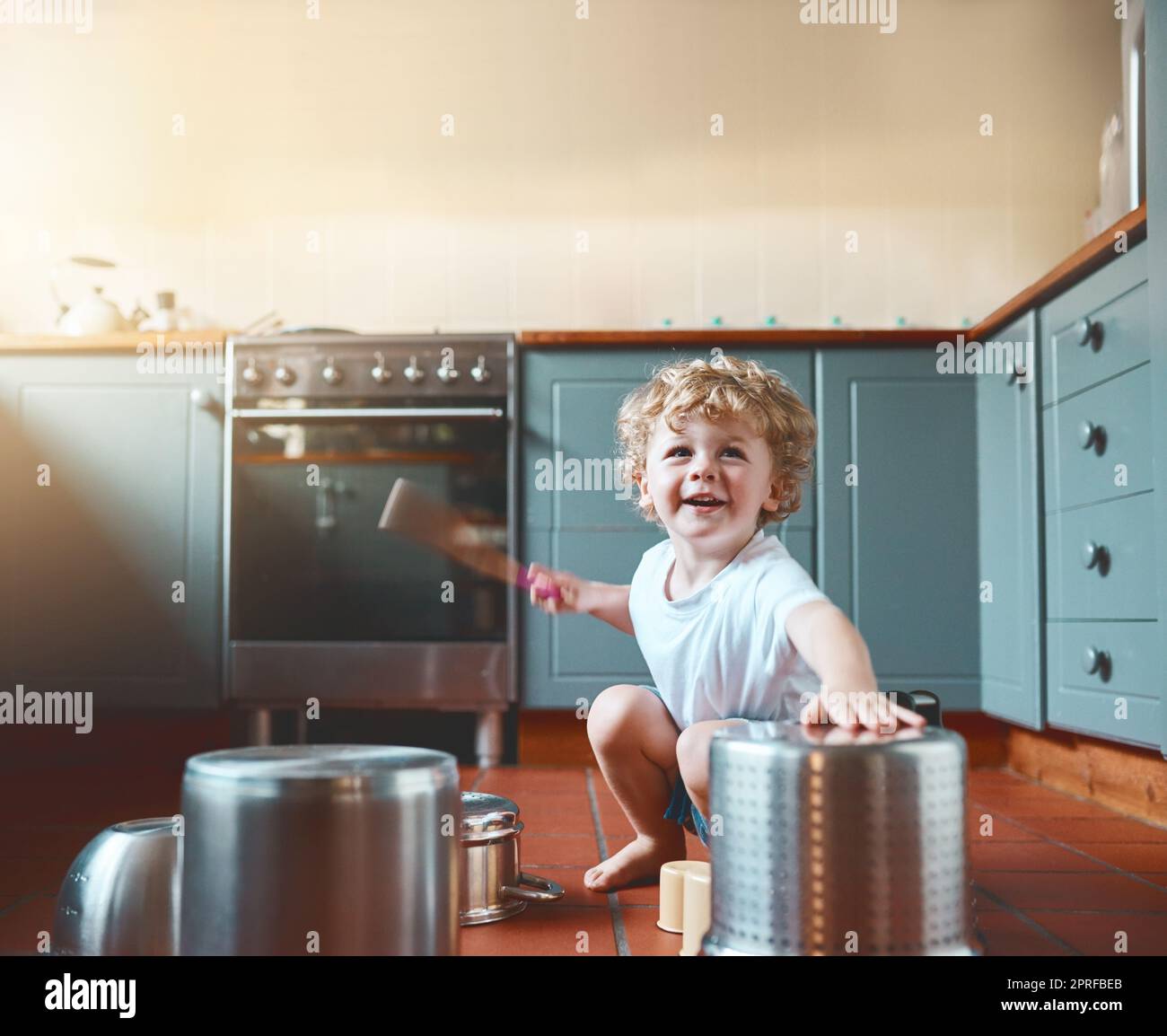 Lasst sie jung und laut sein. Portrait eines entzückenden kleinen Jungen, der in der Küche mit Töpfen spielt. Stockfoto