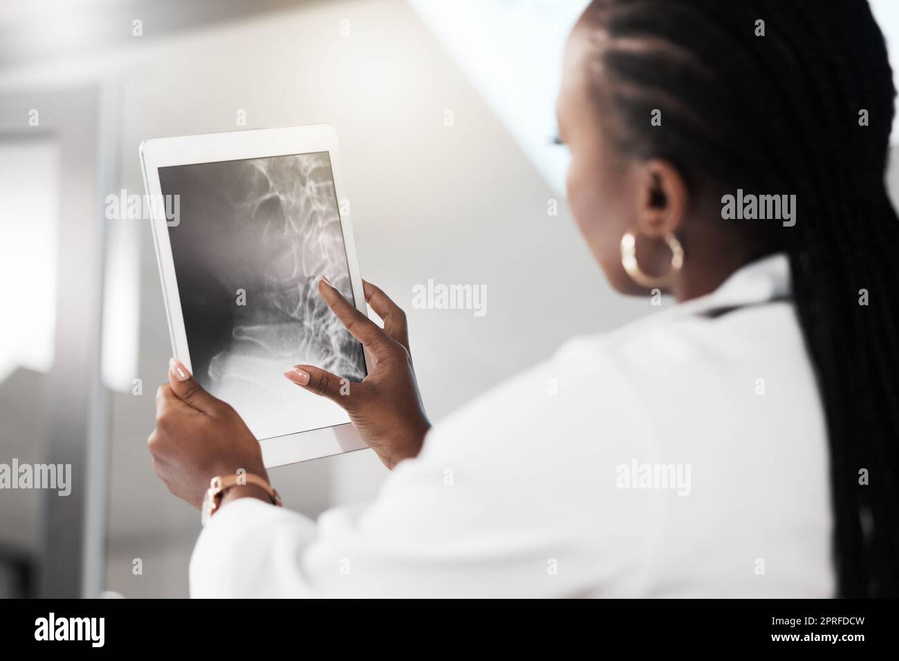 Es ist alles zwischen den Knochen. Ein Arzt, der ein Röntgenbild auf dem Bildschirm eines digitalen Tablets analysiert Stockfoto