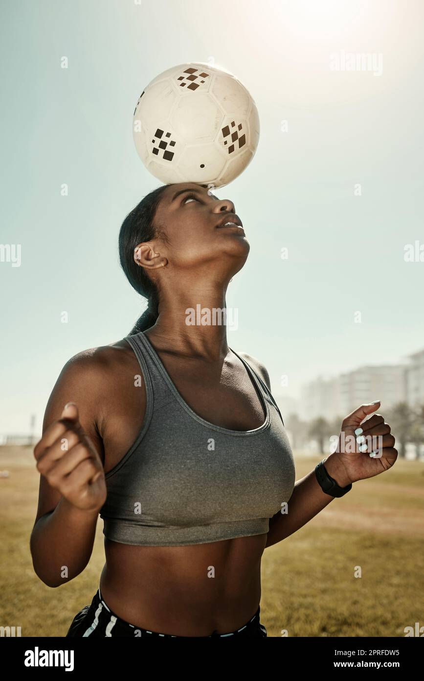 Frau, Fußball und Balance auf dem Kopf auf dem Rasen, auf dem Sportplatz oder im Fitnessclub. Fußballspielerin, schwarze Frau und Sportlerin in Ex Stockfoto