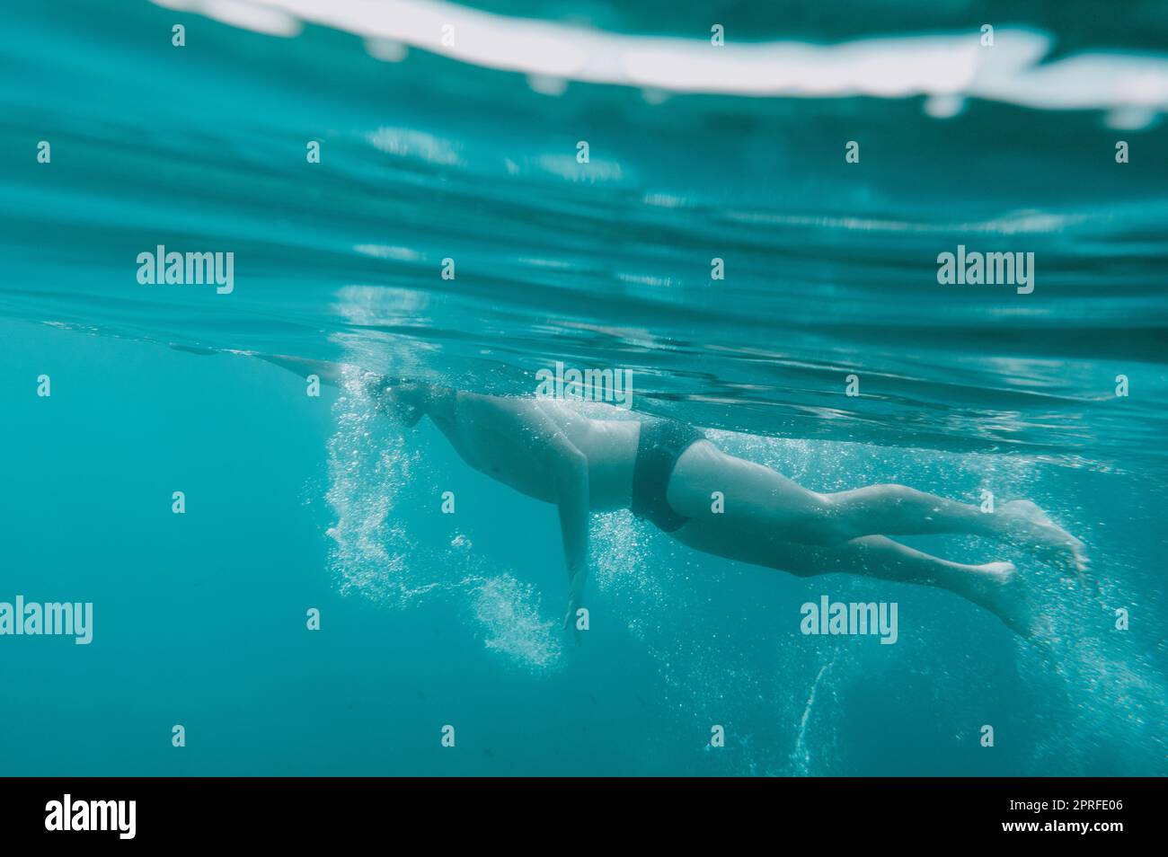 Sportlicher Mann schwimmt schnell im Meer Stockfoto
