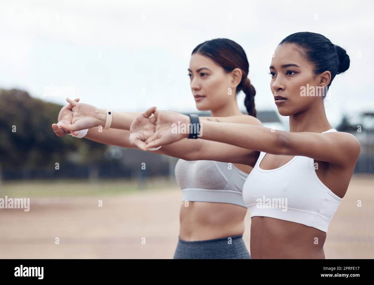 Fitness, Stretching und Diversity Frauen konzentrieren sich auf sportliche Übungen, Marathontraining oder Gesundheitstraining im Outdoor Park. Wellness, Performance Start und Stockfoto