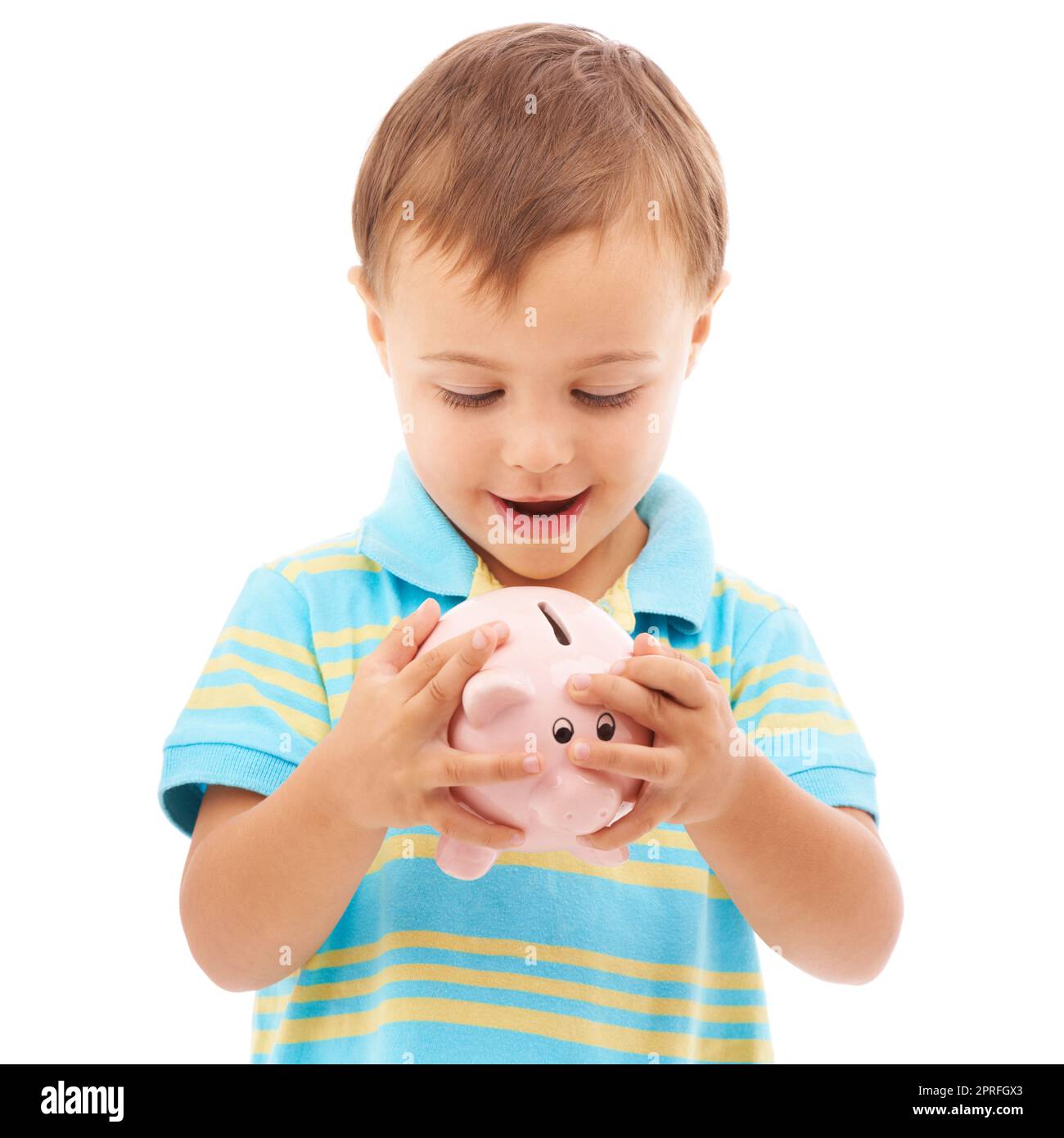 Es fühlt sich so voll an. Studiofoto eines kleinen Jungen, der auf ein weißes Sparschwein schaut Stockfoto