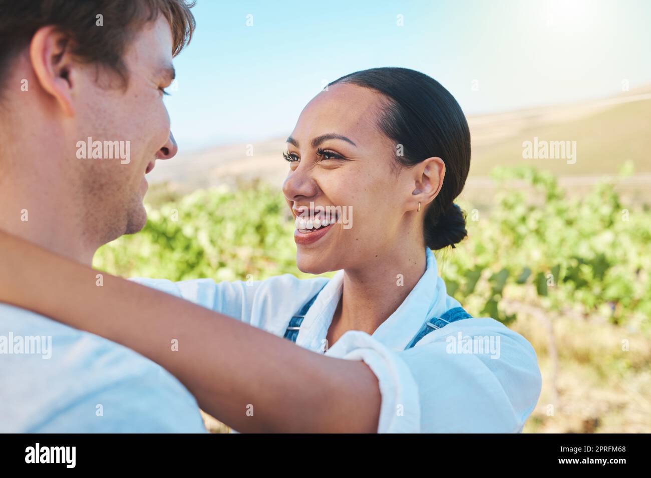 Liebe, Landschaft und ein Paar lächeln, lieben und verbinden sich auf einem sonnigen Weinbauernhof und Naturlandwirtschaft. Gemischtrassige, grüne und glückliche Männer und Frauen reisen im Sommer zu einer Urlaubsreise Stockfoto