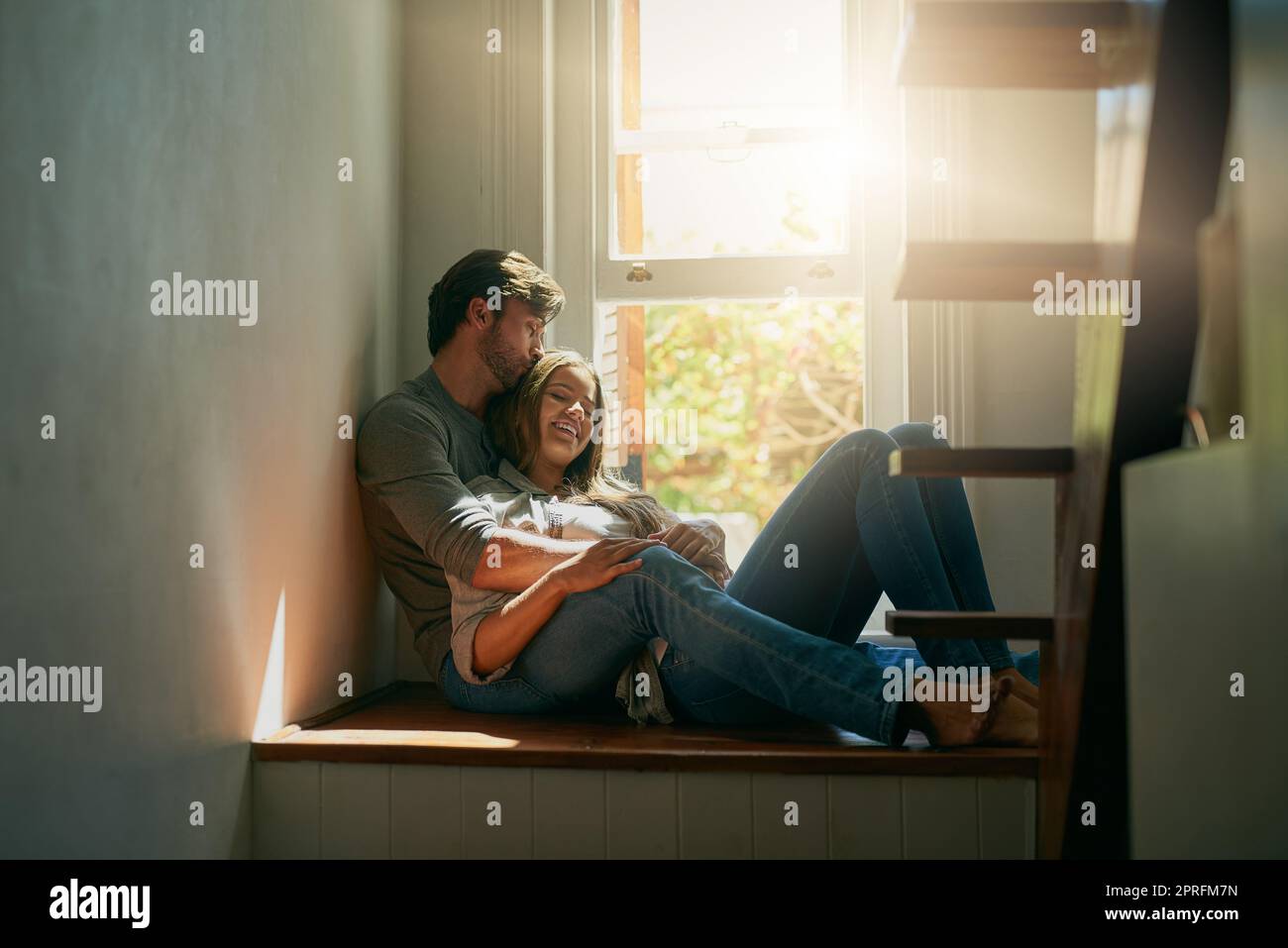 Ich schätze jeden Moment bei euch. Ein liebevolles junges Paar, das sich zu Hause im Sonnenlicht hält. Stockfoto