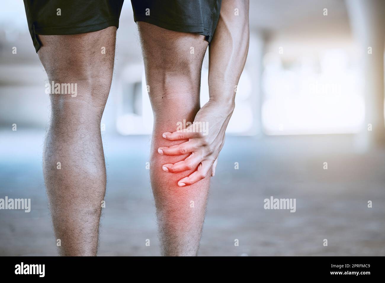 Sportmannhand an einem Bein beim Training, Training oder Workout. Rote Grafik zur Identifizierung von Muskelschmerzen oder Schmerzen im Körper nach einem Laufunfall im Freien. Sportler nach Cardio-Fitness-Routine verletzt Stockfoto