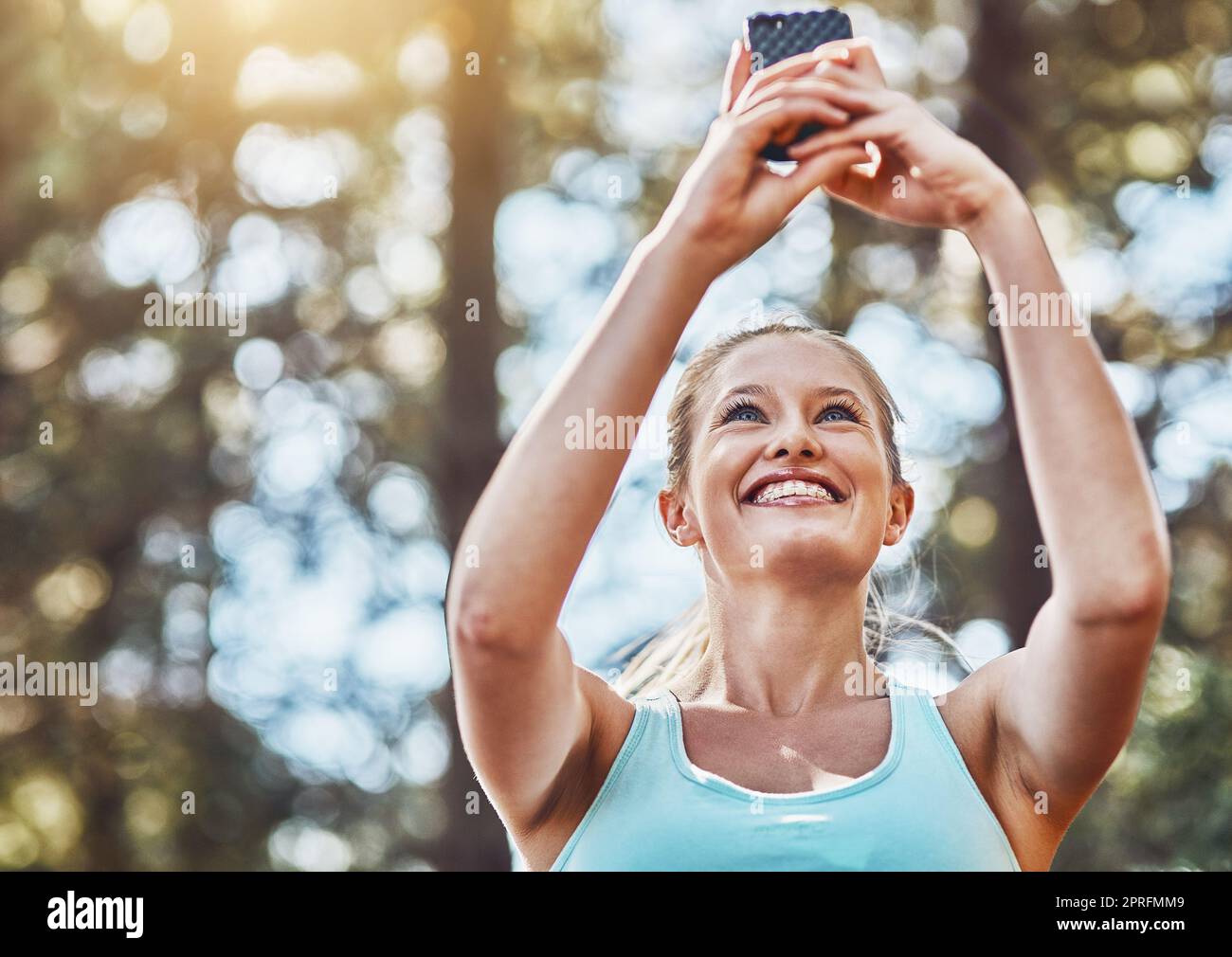 Das Selfie, bevor ich schwitze. Eine junge Frau, die vor ihrem Training im Freien ein Foto von sich macht. Stockfoto