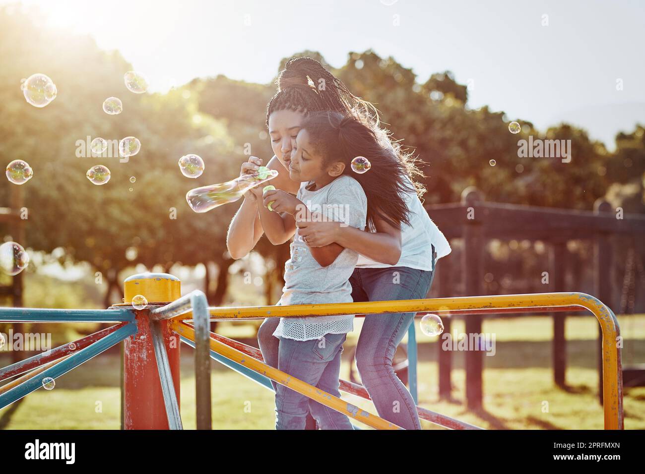 Blasen machen die Welt heller. Eine Mutter und ihre Tochter blasen Blasen im Park. Stockfoto