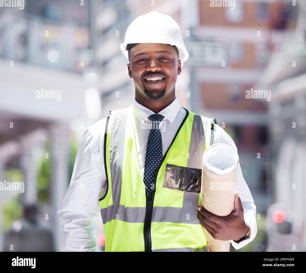 Geschäftsleute, Bauunternehmer und Bauunternehmer, die Baupläne mit einer Vision für den Erfolg im Bauwesen haben. Porträt eines glücklichen, lächelnden schwarzen Mannes mit einem Plan und einer Idee für Architekturdesign in der Stadt. Stockfoto