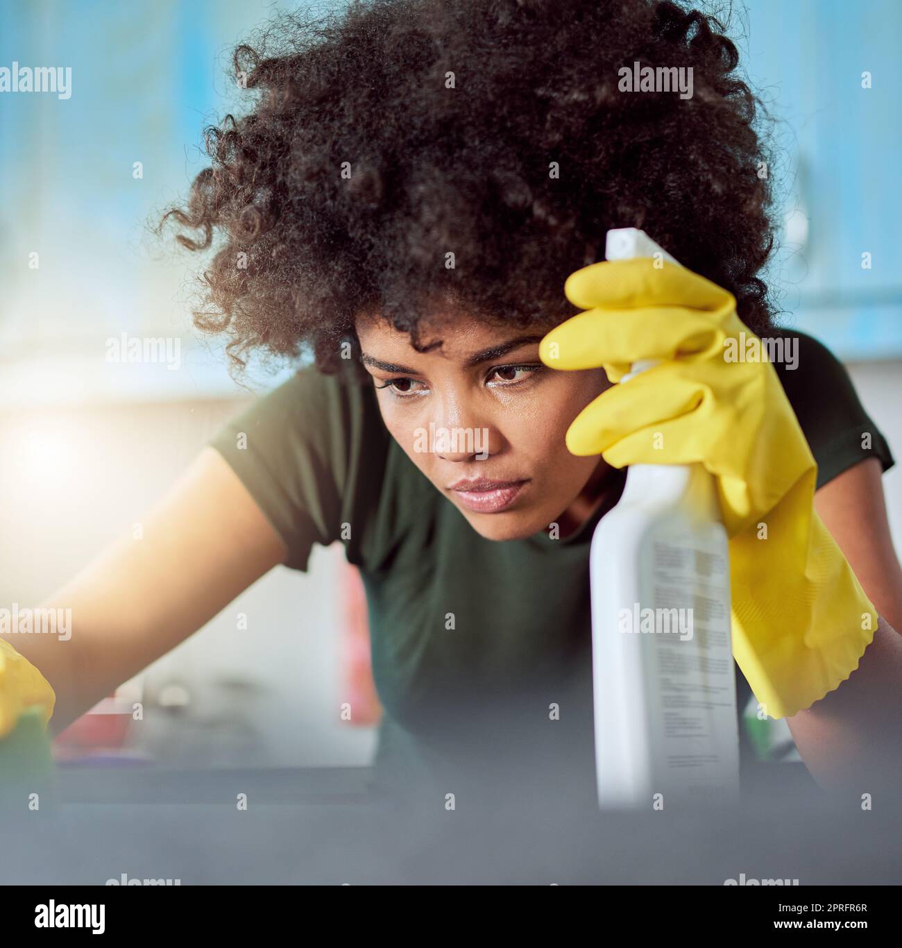 Ich habe keine Angst vor Keimen. Eine attraktive junge Frau mit gelben Handschuhen, die ihr Zuhause putzt. Stockfoto
