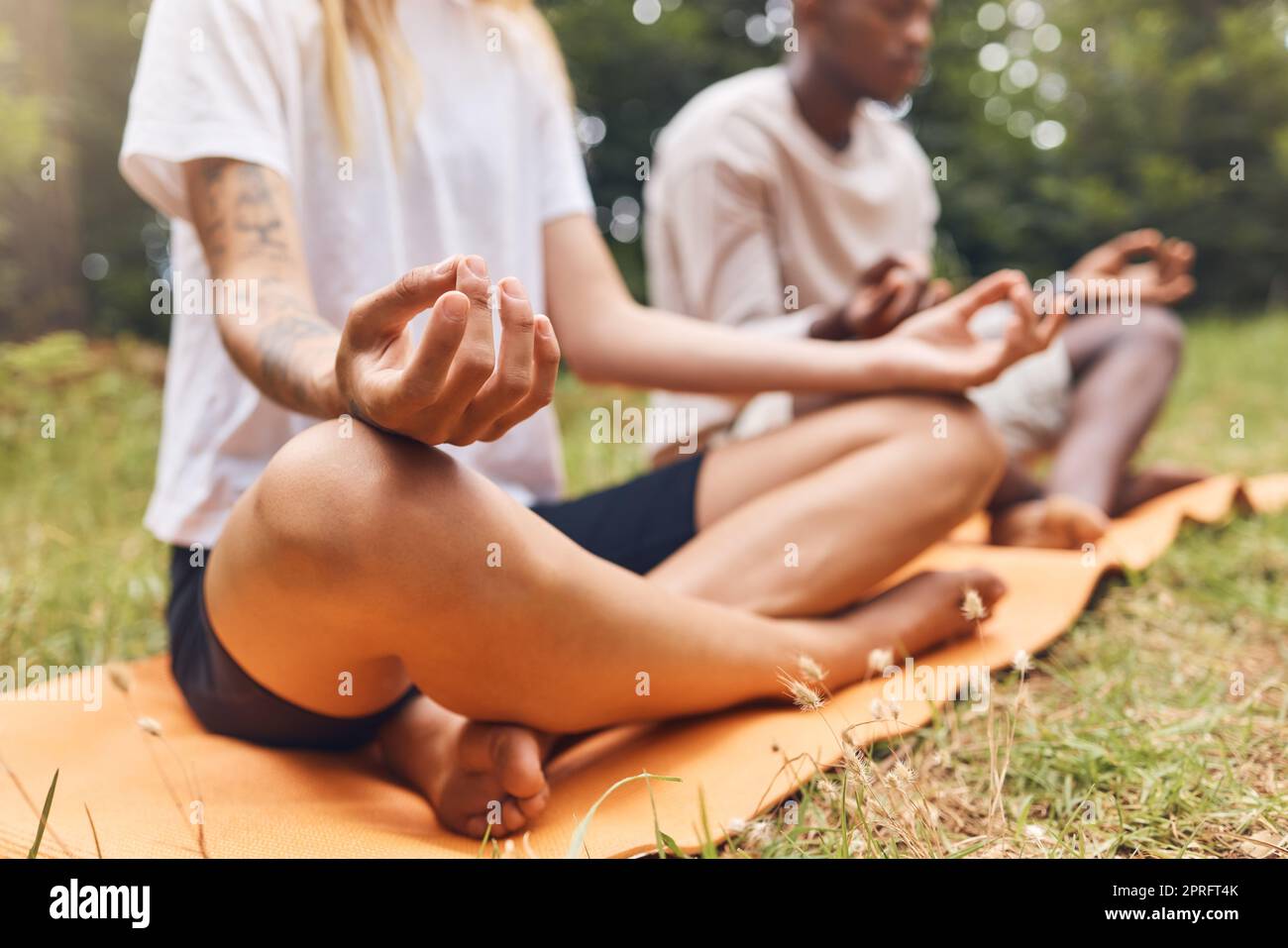 Park-Yoga-Meditation, Zen- und Mudra-Hände-Geste in Lotus-Pose für Natursport und Training. Ruhige Energie, gesunde und fokussierte Menschen mit überkreuzten Beinen Training für Frieden, Wellness Gleichgewicht und Entspannung Stockfoto