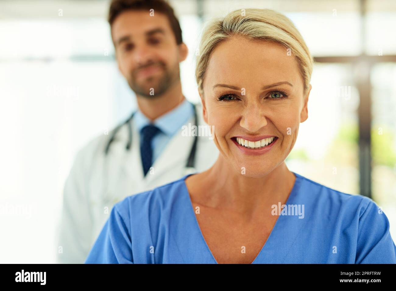 Ich habe eine Karriere aus Mitgefühl gemacht. Porträt zweier glücklicher Heilpraktiker, die in einem Krankenhaus zusammen posieren. Stockfoto