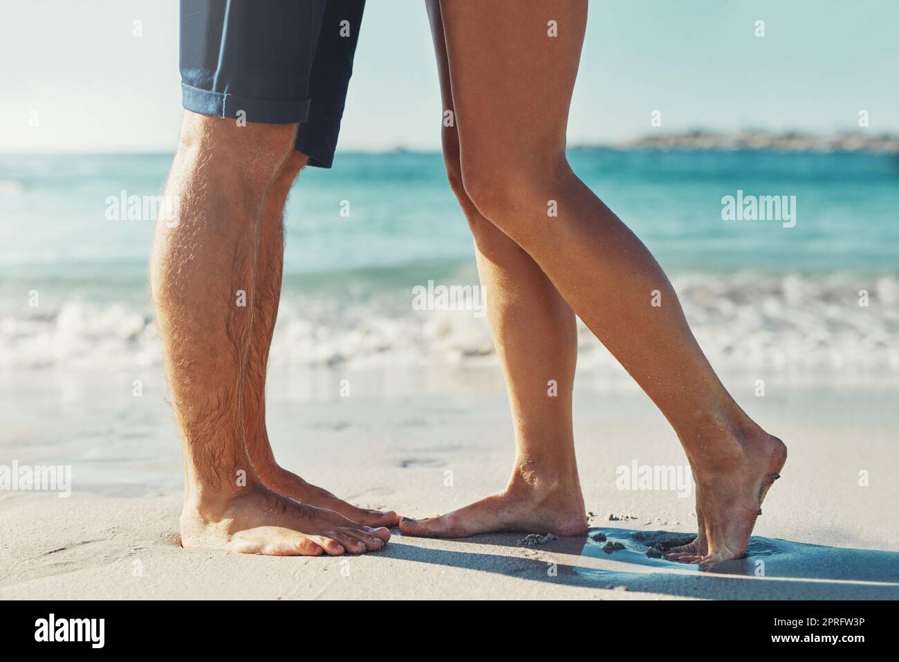 Sommer hier. Ein unverkennbares Paar, das am Strand am Rand des Wassers zusammensteht. Stockfoto