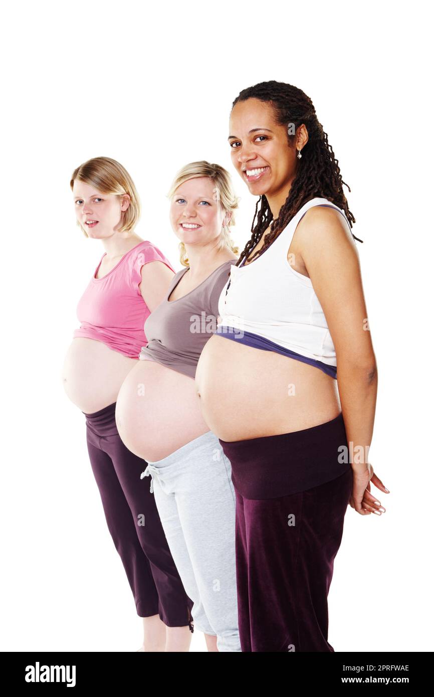 Schwangere Gruppe von Frauen in Reihe mit Bauch, Bauch und Bauch zeigt für Mutterschaft, Gesundheit und Mutterschaft vor einem weißen Studiohintergrund. Porträt der Diversitätsgemeinschaft aufgeregter glücklicher Mütter Stockfoto