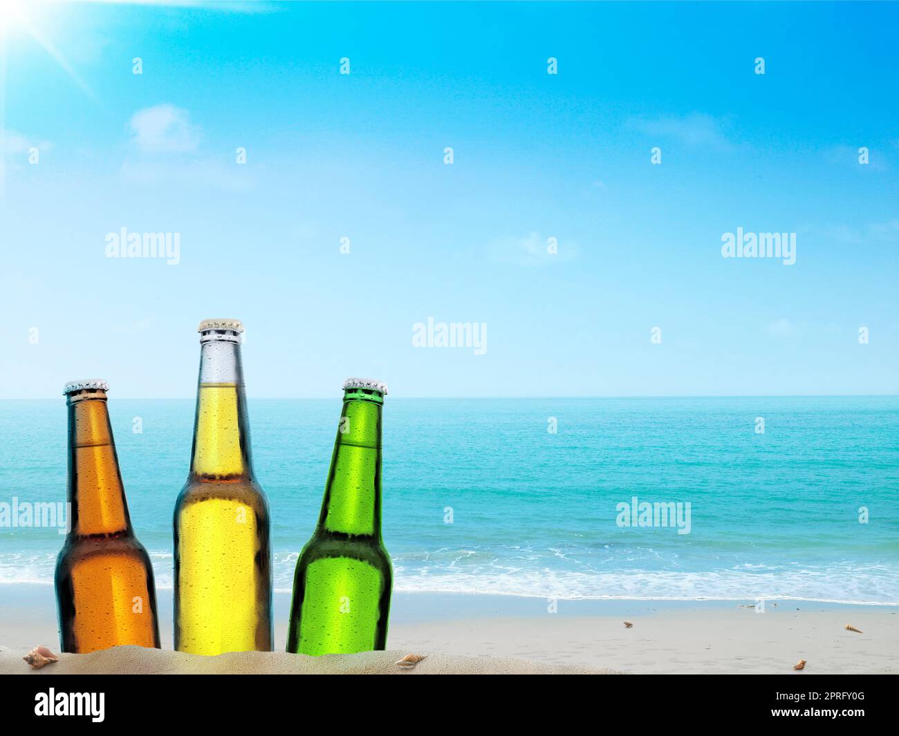 Eine Flasche Bier an einem Sandstrand mit klarem Himmel Stockfoto