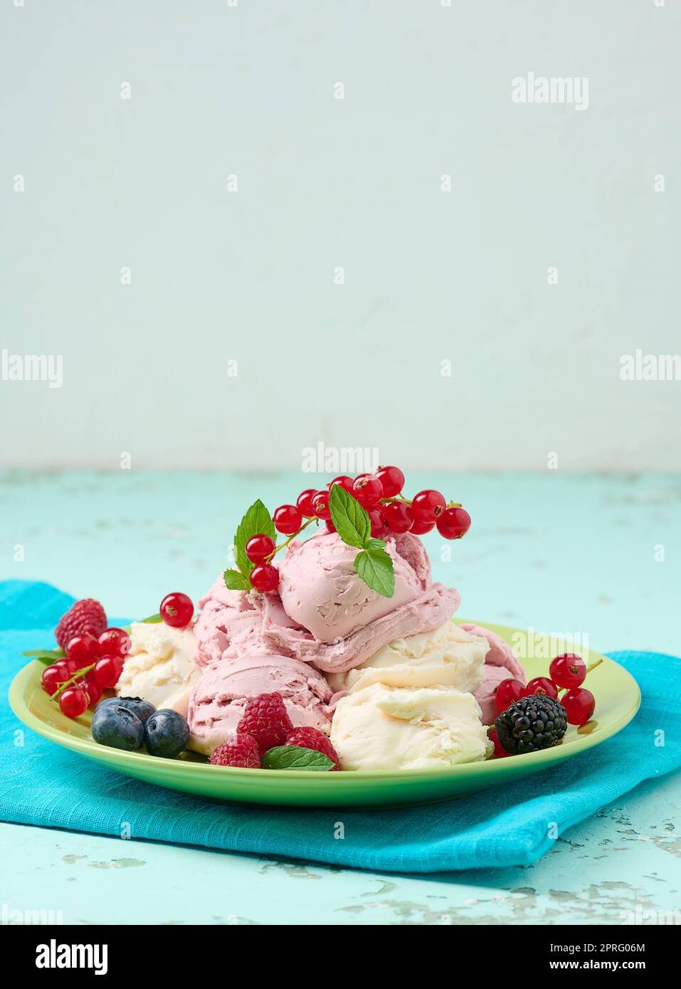 Vanilleeiskugeln mit roten Himbeeren auf einem runden Teller. Stockfoto