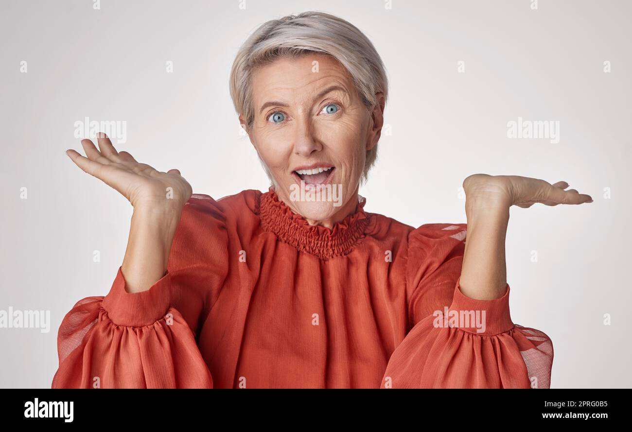Wow und eine ältere Frau mit Emoji-Handgesten oder Gesichtsausdruck auf grauem Studiohintergrund überraschen. Senior-Modefrau mit Händen für schockierende, unglaubliche Pensions-, Discount- oder Sonderangebote Stockfoto